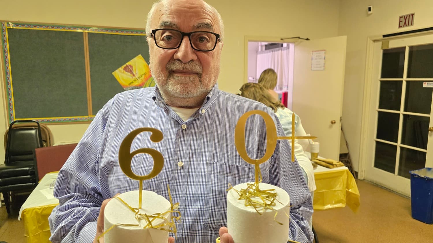 A guest at the 60+ gathering, holding the gold numerals